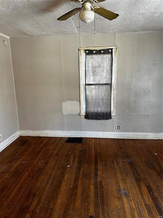 empty room with ceiling fan, a textured ceiling, and hardwood / wood-style flooring