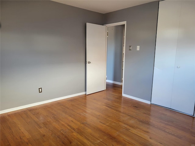 unfurnished bedroom with a closet and hardwood / wood-style floors