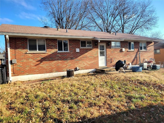 rear view of property with a yard and cooling unit