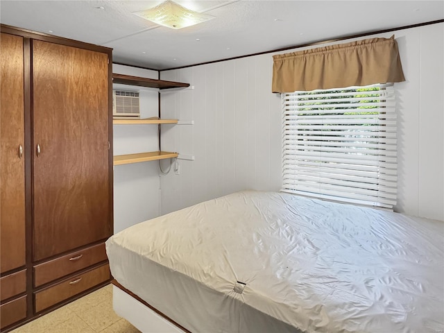 bedroom featuring a wall mounted AC and wood walls