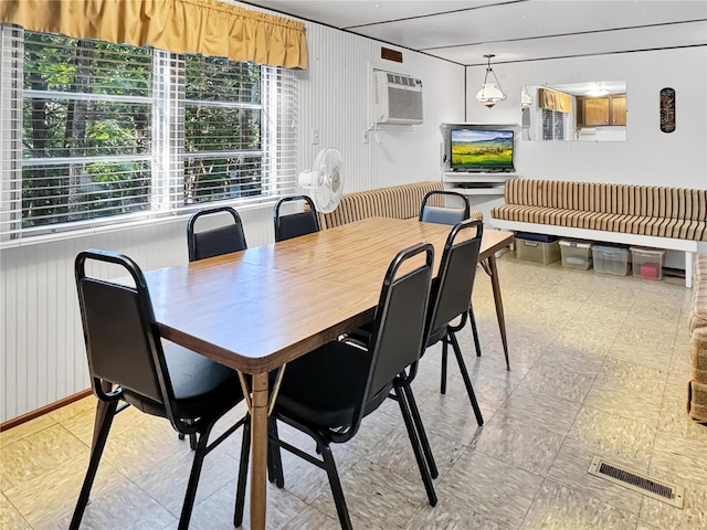 dining area featuring wooden walls and a wall mounted AC