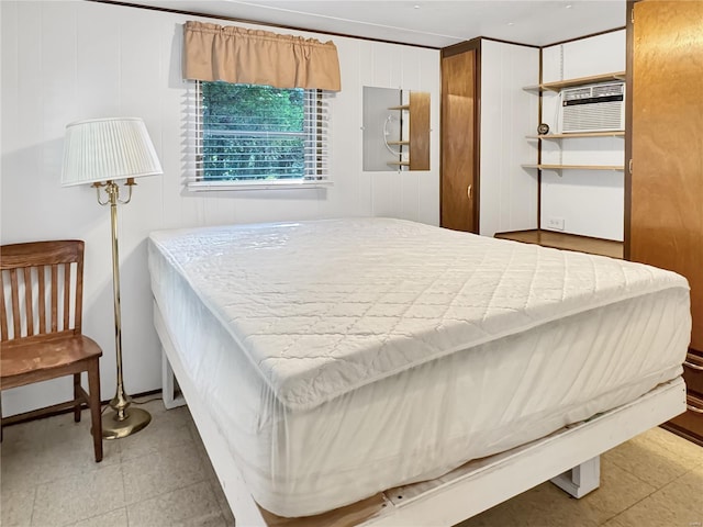 bedroom featuring wooden walls and an AC wall unit