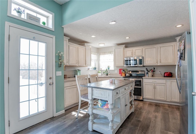 kitchen with stainless steel appliances, white cabinets, a textured ceiling, and dark wood-type flooring