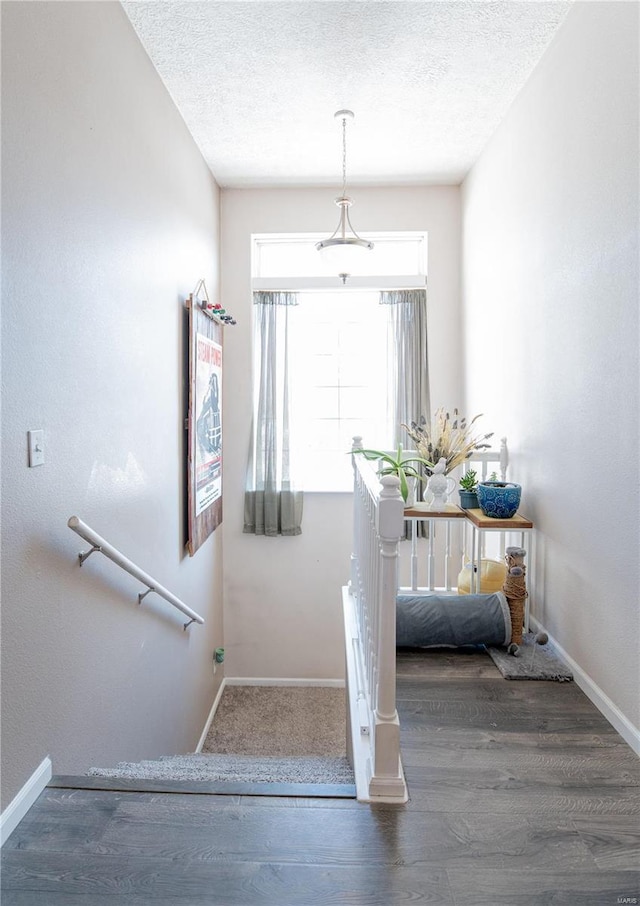 stairway featuring a textured ceiling and hardwood / wood-style flooring