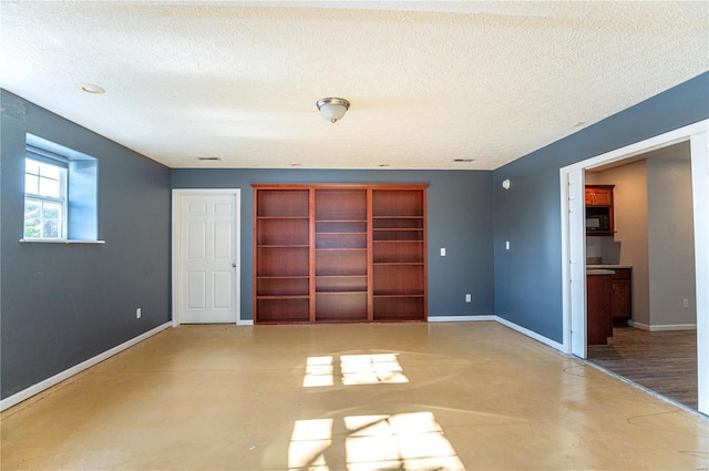 unfurnished bedroom with a textured ceiling, concrete floors, and a closet