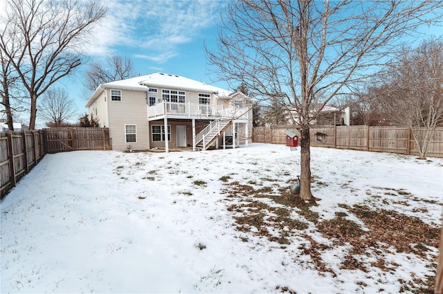 snow covered house featuring a deck