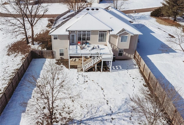 snow covered back of property featuring a wooden deck