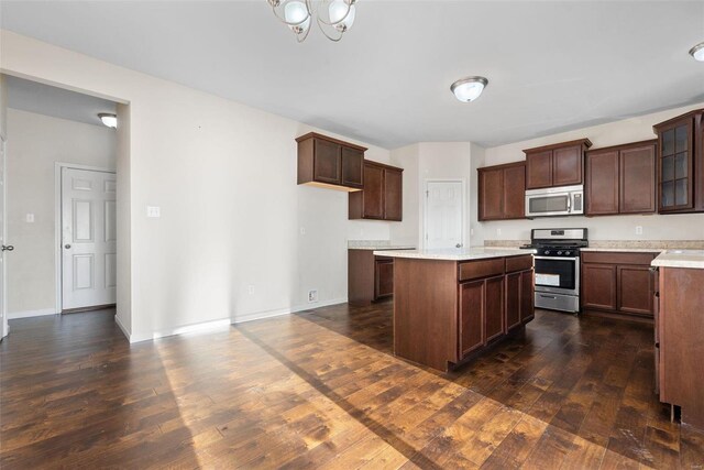 kitchen with dark brown cabinetry, appliances with stainless steel finishes, dark hardwood / wood-style floors, and a center island