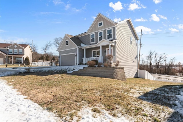 view of front of home with a garage, a front yard, and a porch