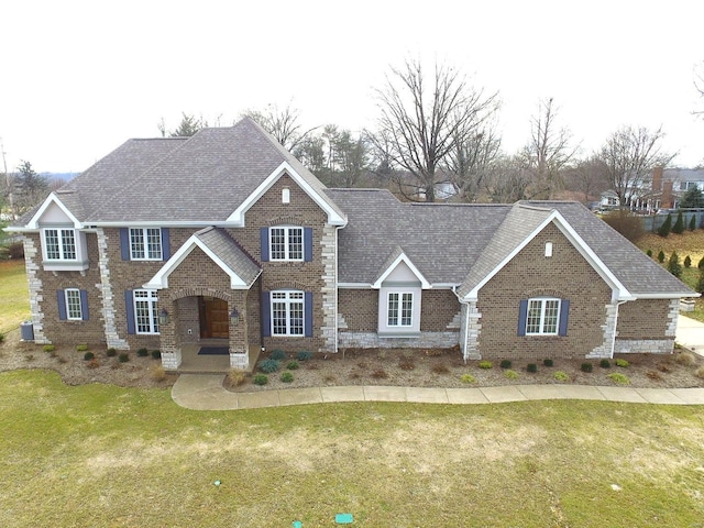 view of front facade featuring a front yard and central air condition unit