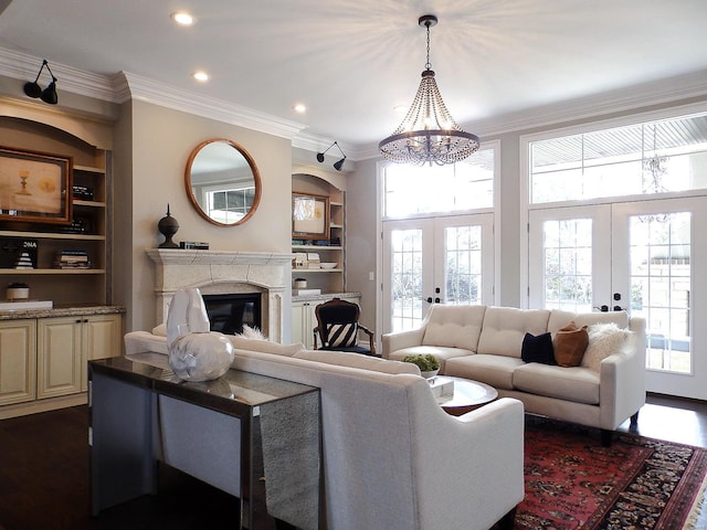 living room with french doors, plenty of natural light, dark hardwood / wood-style floors, and built in shelves