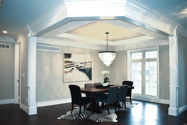 dining room featuring a tray ceiling, crown molding, dark wood-type flooring, and a chandelier