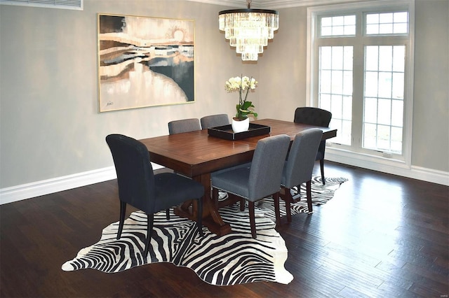 dining room featuring crown molding, dark hardwood / wood-style flooring, and a chandelier