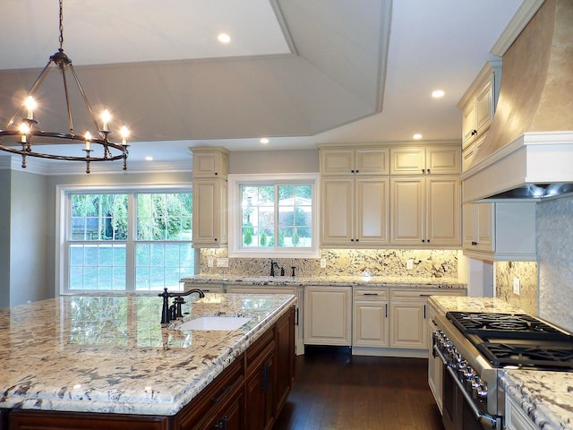 kitchen with sink, hanging light fixtures, light stone counters, custom exhaust hood, and range with two ovens