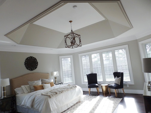 bedroom featuring an inviting chandelier, crown molding, wood-type flooring, and a raised ceiling