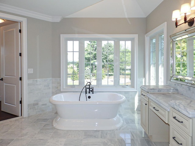 bathroom with tile walls, vanity, and a bathing tub