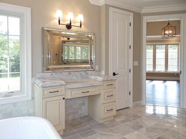 bathroom with an inviting chandelier, vanity, a bathtub, and ornamental molding