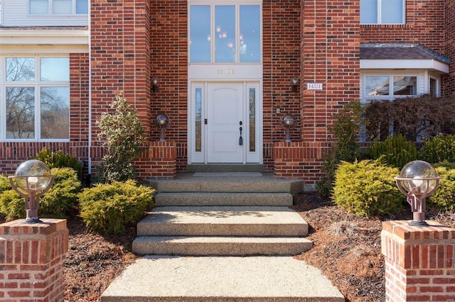 doorway to property with brick siding