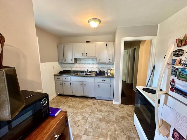 kitchen with white cabinets, white refrigerator, electric stove, sink, and tasteful backsplash