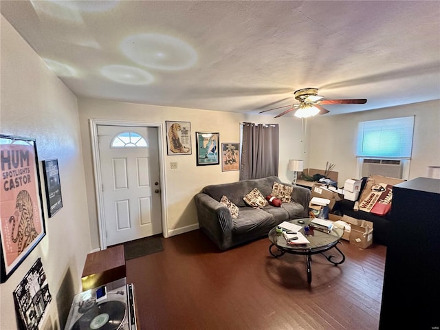 living room with a textured ceiling, hardwood / wood-style flooring, cooling unit, and ceiling fan