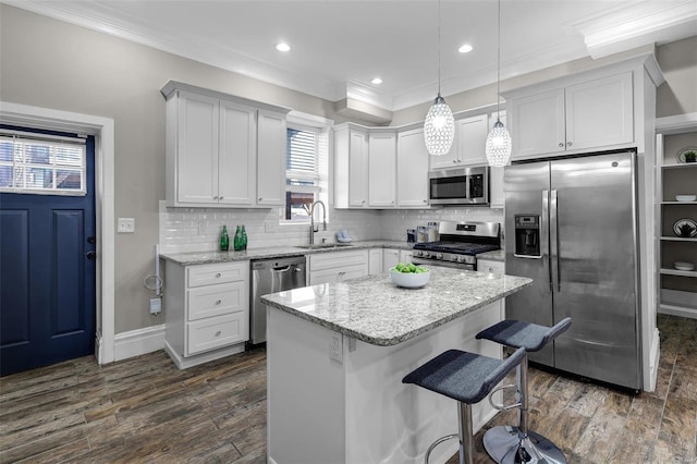 kitchen featuring white cabinetry, sink, decorative light fixtures, and stainless steel appliances