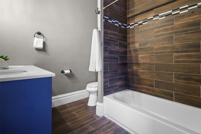 full bathroom featuring vanity, tiled shower / bath, and toilet