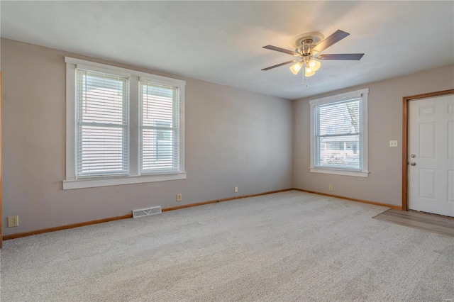 carpeted spare room featuring ceiling fan