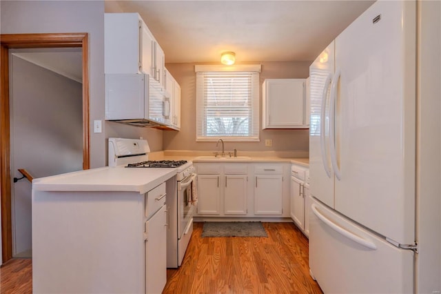 kitchen featuring white cabinetry, white appliances, sink, and light wood-type flooring