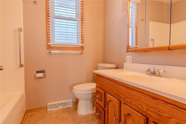 bathroom featuring vanity, tile patterned flooring, a bathing tub, and toilet