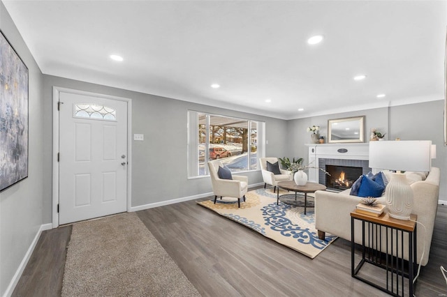 living room with hardwood / wood-style flooring and a brick fireplace