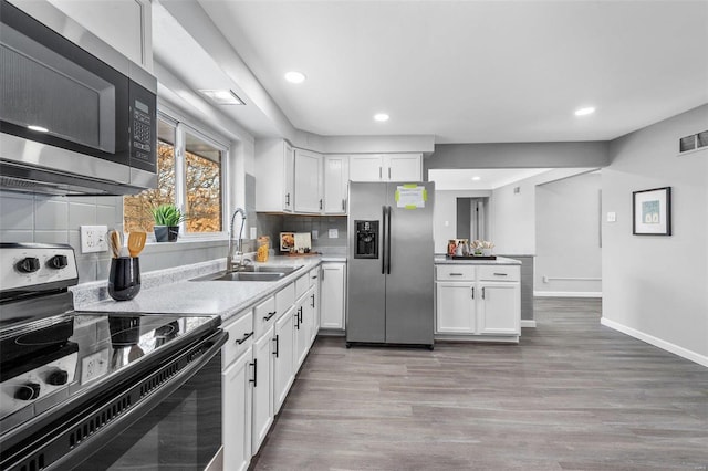 kitchen featuring stainless steel appliances, sink, white cabinets, and decorative backsplash