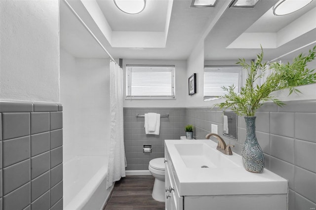 full bathroom featuring toilet, vanity, a tray ceiling, shower / bath combo, and hardwood / wood-style flooring