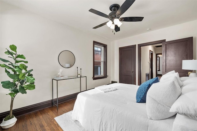 bedroom with dark hardwood / wood-style flooring and ceiling fan