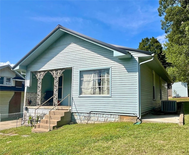 bungalow-style house featuring central air condition unit and a front yard