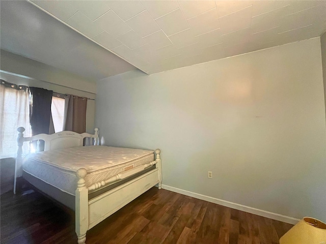 bedroom with dark hardwood / wood-style floors