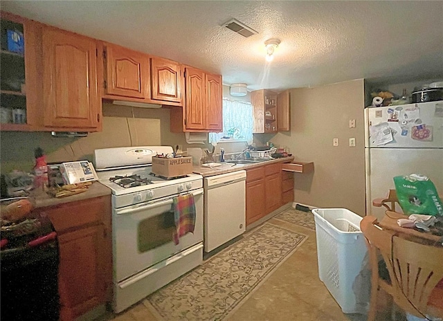 kitchen featuring sink, white appliances, and a textured ceiling