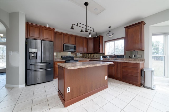 kitchen featuring sink, a center island, light tile patterned floors, appliances with stainless steel finishes, and pendant lighting