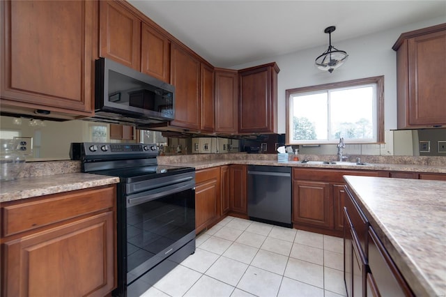 kitchen with sink, decorative light fixtures, light tile patterned floors, and appliances with stainless steel finishes