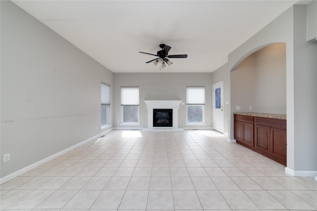 unfurnished living room featuring light tile patterned floors and ceiling fan