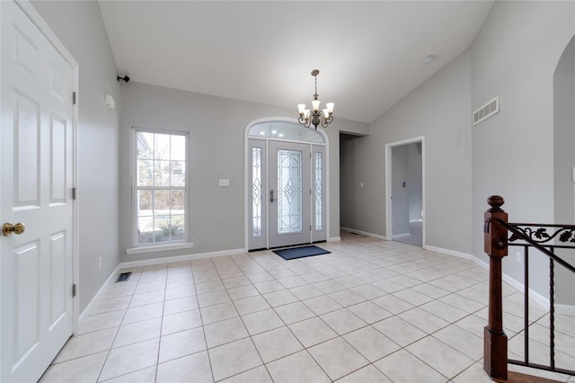 tiled foyer with an inviting chandelier and vaulted ceiling