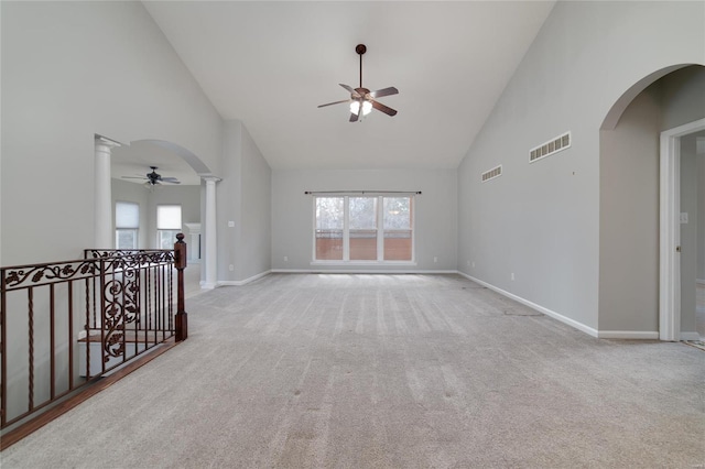 spare room featuring ceiling fan, high vaulted ceiling, light carpet, and ornate columns