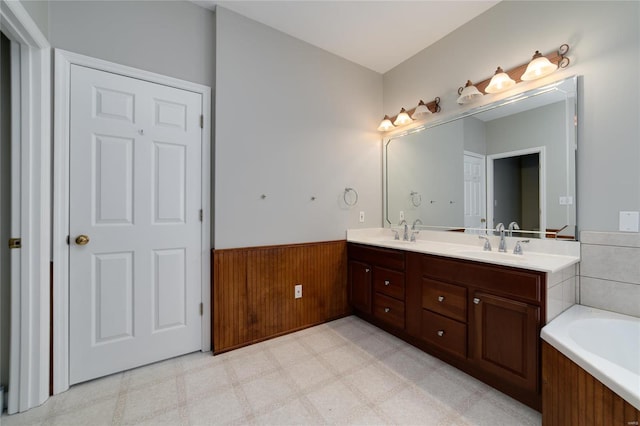 bathroom with vanity, a bathtub, and wooden walls