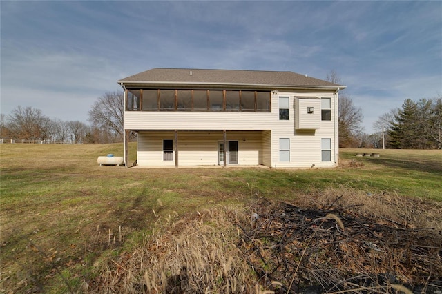 back of house featuring a sunroom and a lawn