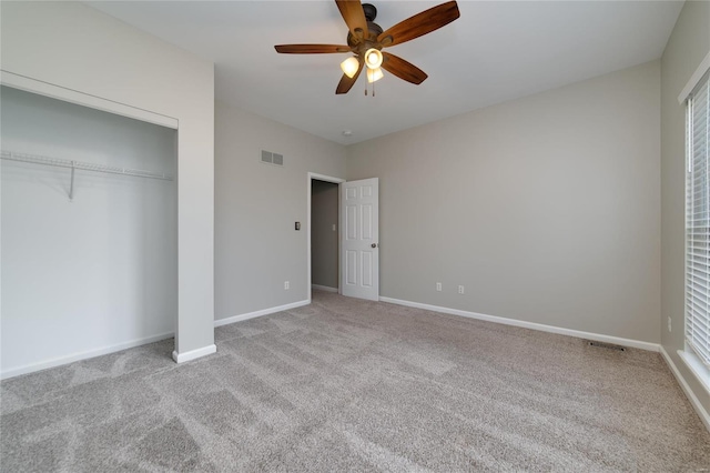 unfurnished bedroom featuring ceiling fan, light colored carpet, and a closet