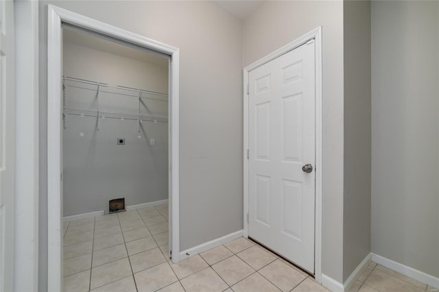 laundry area with hookup for an electric dryer and light tile patterned floors