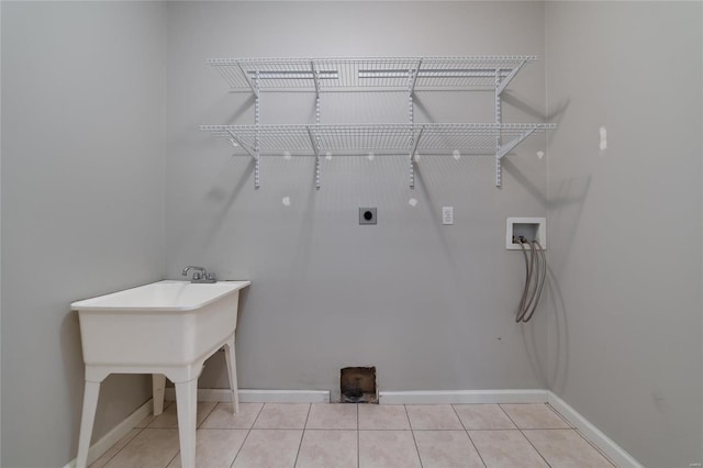 laundry area with light tile patterned floors, hookup for a washing machine, hookup for an electric dryer, and hookup for a gas dryer