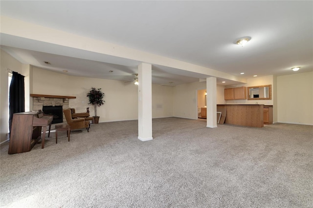 living room featuring a stone fireplace and light colored carpet