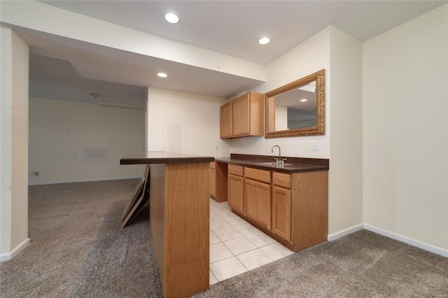 kitchen with light colored carpet, a breakfast bar, kitchen peninsula, and sink