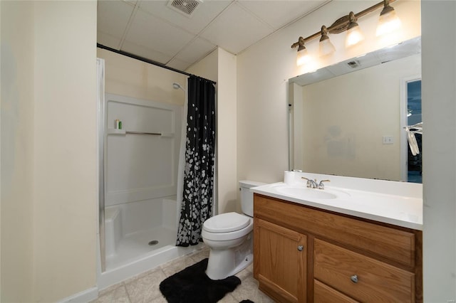 bathroom featuring toilet, a shower with curtain, a paneled ceiling, vanity, and tile patterned flooring