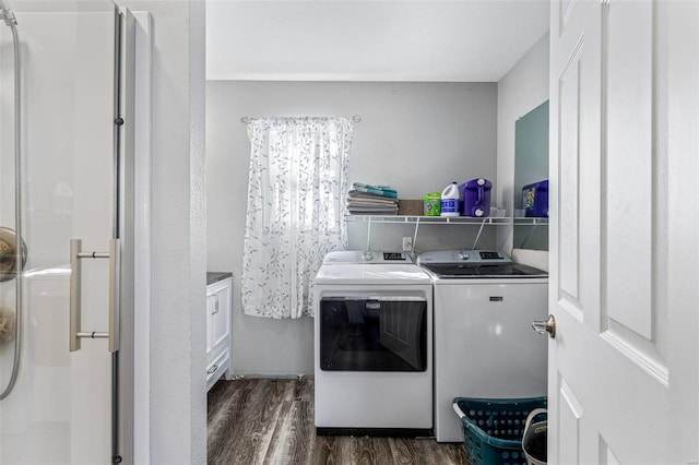 clothes washing area with washer and clothes dryer and dark hardwood / wood-style floors